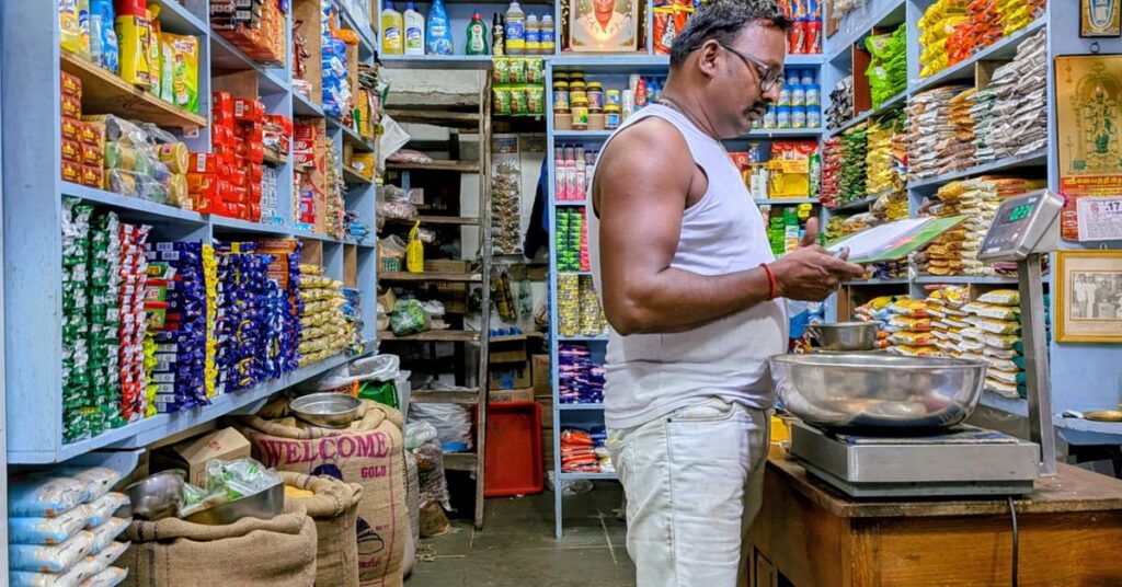 Grocery shop owner checking stock, showing how to start a business in India