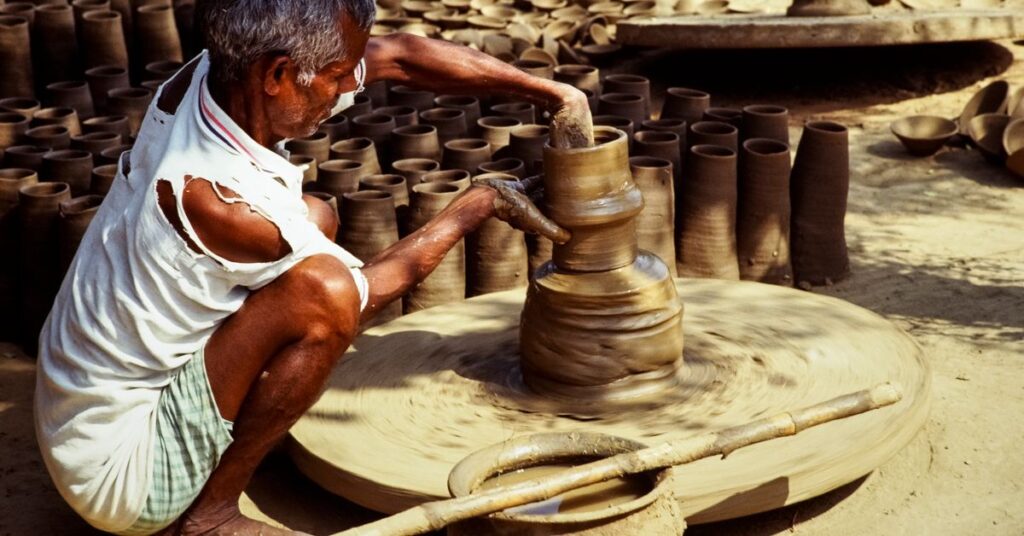 Indian potter shaping clay on a wheel, a trade covered by the PM Vishwakarma Yojana