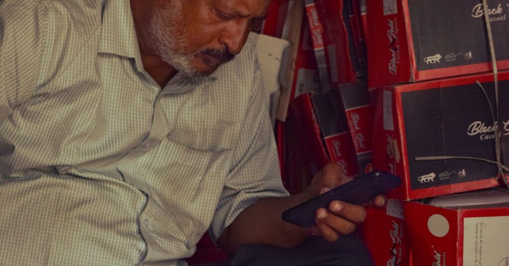 Small shop owner applying for an SBI e Mudra loan on a mobile phone